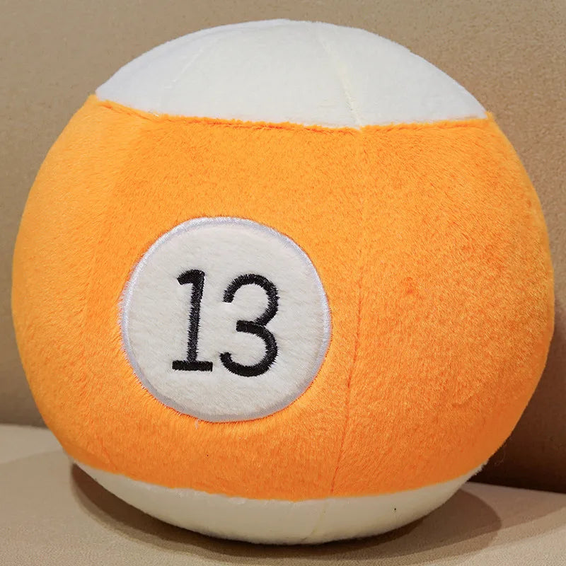 Billiard Ball Plush Set orange striped number 13 ball resting on a beige seat.