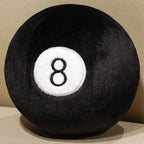 Billiard Ball Plush Set black number 8 ball resting on a beige seat.