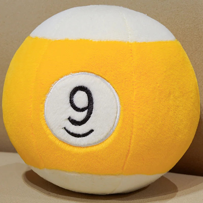 Billiard Ball Plush Set yellow striped number 9 ball resting on a beige seat.