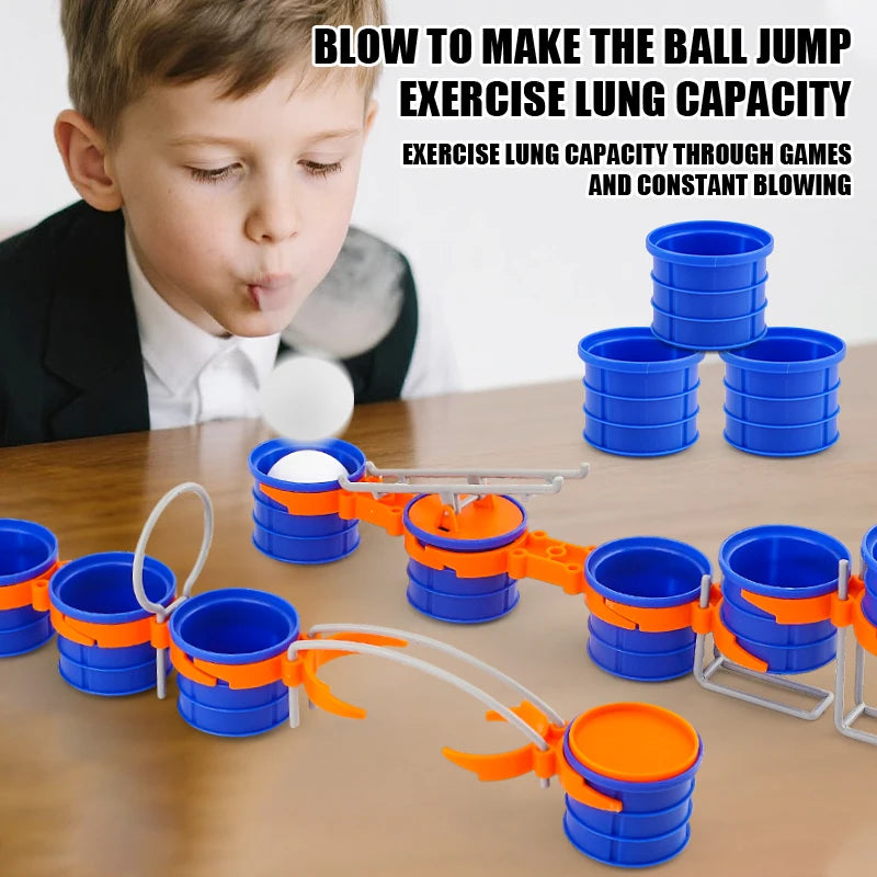 Blow Ball Race Game tabletop demonstration of a player blowing a white ball toward blue cups