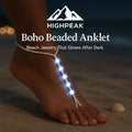 HighPeak Boho Beaded Anklet glowing white on dark beach sand, adjustable glow-in-the-dark resin beads design