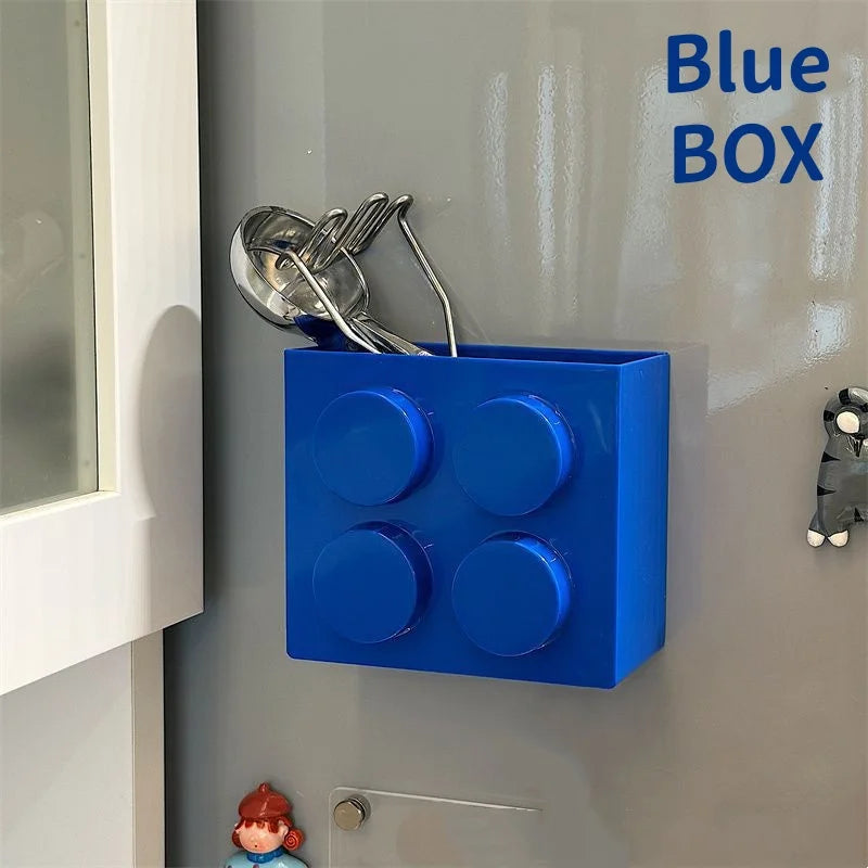 Building Block Storage Bins — Blue magnetic bin holding metal kitchen utensils on a fridge door.