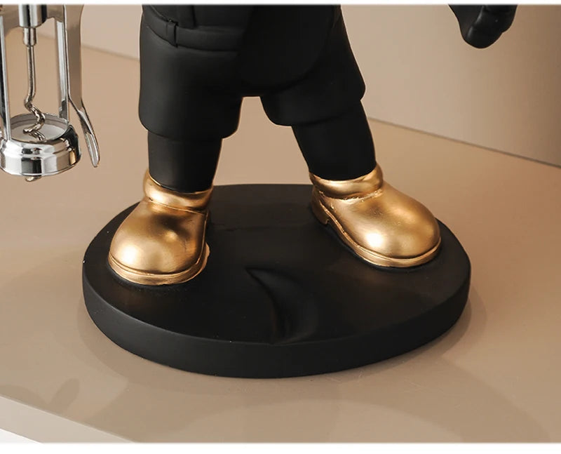 Bulldog Wine Bottle Holder close-up of gold-tone shoes and the black round base on the bottle-holding style.