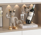 Bulldog Wine Bottle Holder grey glass and bottle styles with gold-tone accents displayed beside a framed print.