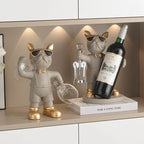 Bulldog Wine Bottle Holder grey bottle and glass styles on a sideboard, with the bottle style raised on a book.