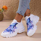 Butterfly Knit Shoes Blue Butterfly shoes worn with crossed ankles, showing the front and side of the chunky soles.