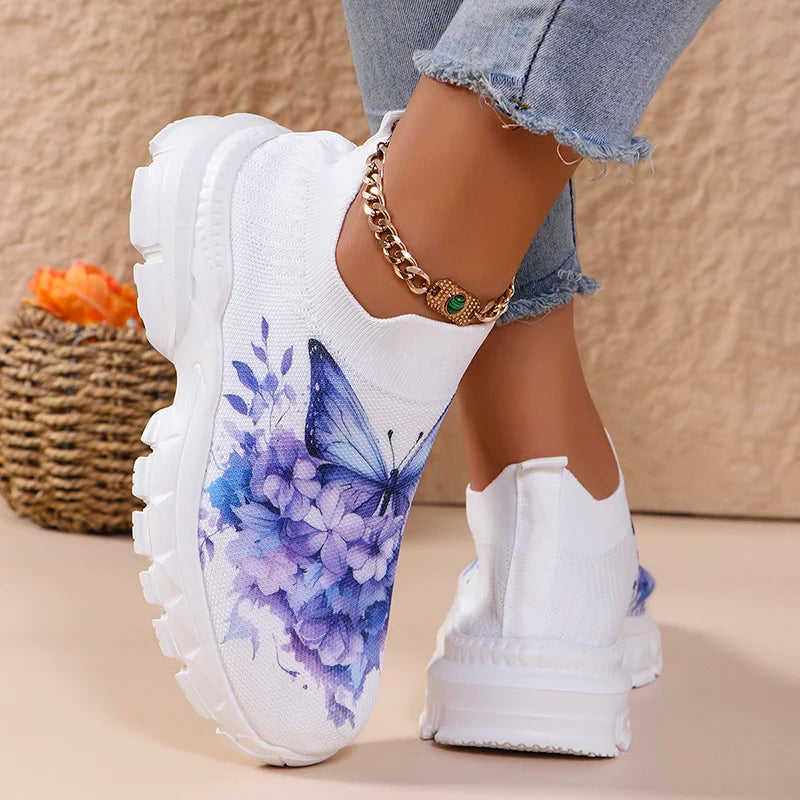 Butterfly Knit Shoes Blue Butterfly shoes with one foot raised, showing the rear pull tab and segmented sole profile.