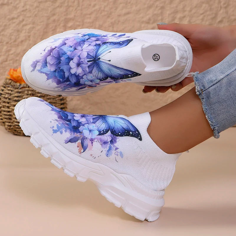 Butterfly Knit Shoes Blue Butterfly shoe held above a worn shoe, showing the white insole and floral knit upper.