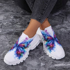 Butterfly Knit Shoes Colorful Butterfly shoes worn with crossed ankles on a gray floor, showing both printed uppers.