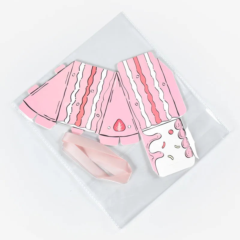 Cake Slice Favor Boxes in pink shown unassembled with foldable paperboard pieces and ribbon