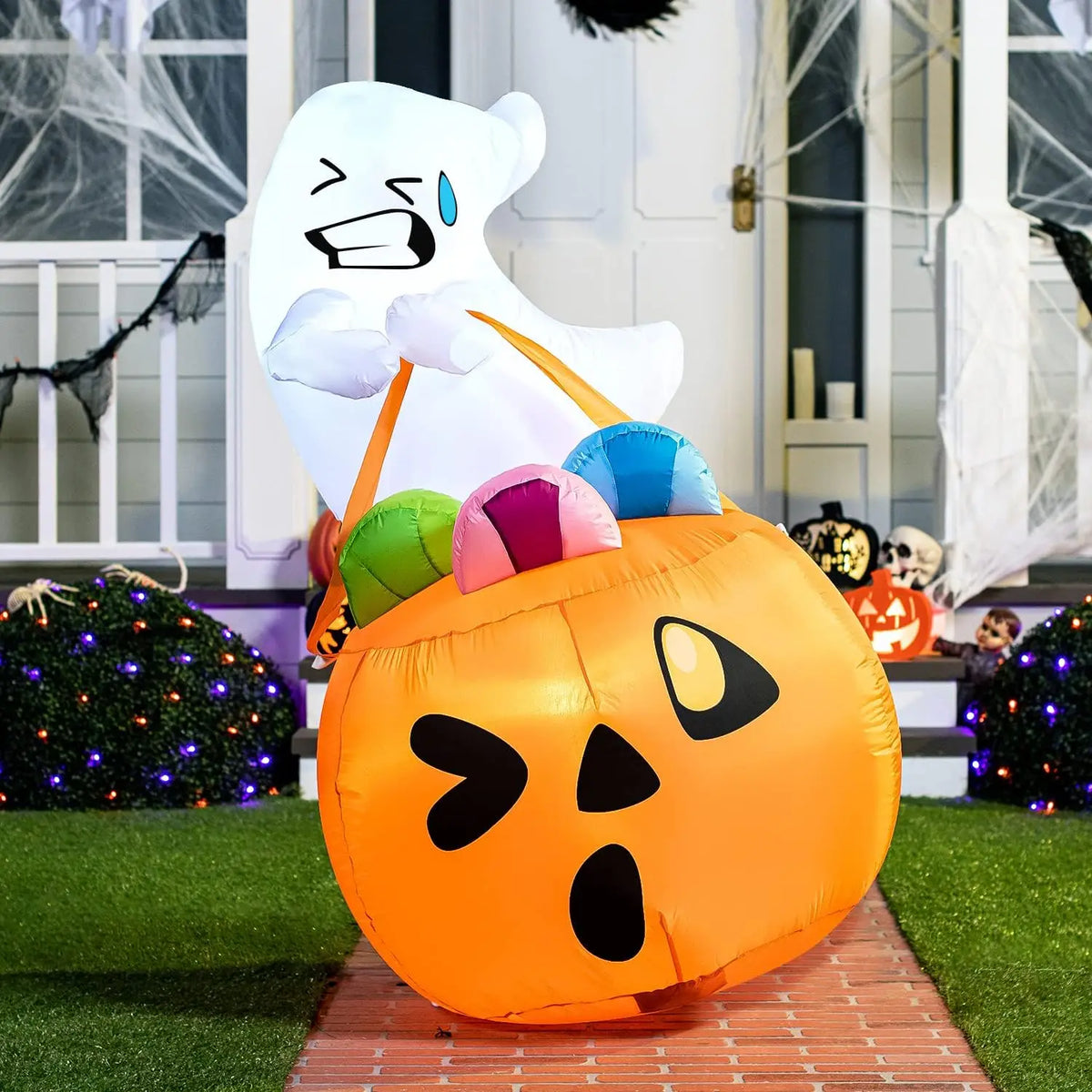 Candy-Carrying Ghost Inflatable with a winking orange pumpkin bag and colorful candy outside a decorated porch.