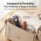 Cat Paw Box Cutter with blade retracted, shown inside a handbag beside personal accessories.