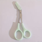 BrowCraft™ eyebrow trimming scissors with built-in comb and mint green handles on light background by HighPeak