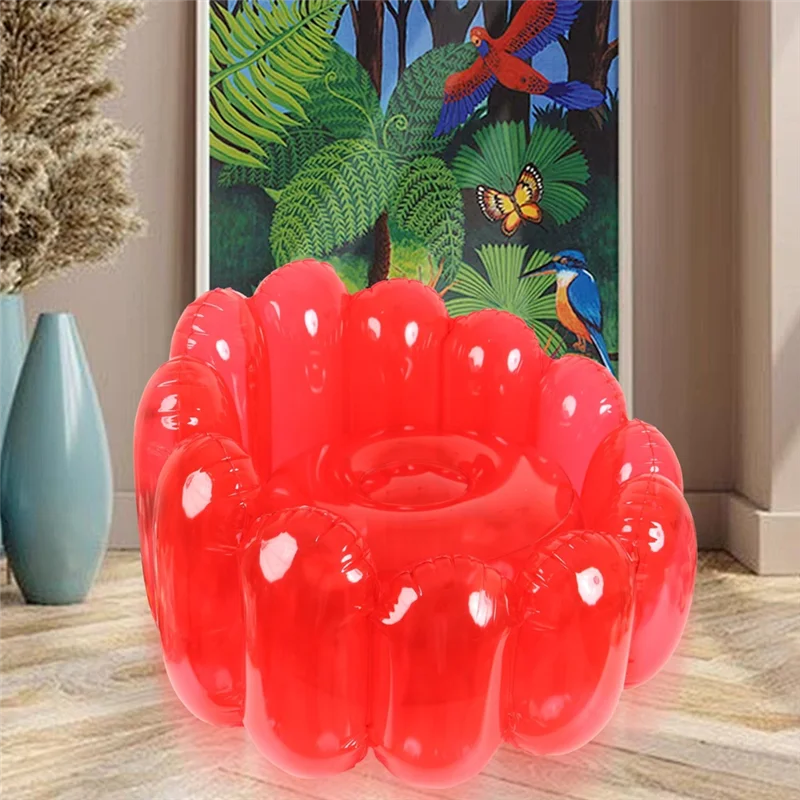 Cherry Jelly Inflatable Chair in red styled in a living room beside tropical wall art.