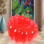 Cherry Jelly Inflatable Chair in red styled in a living room beside tropical wall art.