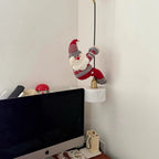 Christmas Chandelier Hugger Santa character hanging from a cord above a home office monitor