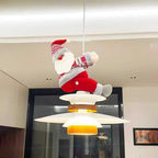 Christmas Chandelier Hugger Santa character sitting on a layered pendant light above a dining area