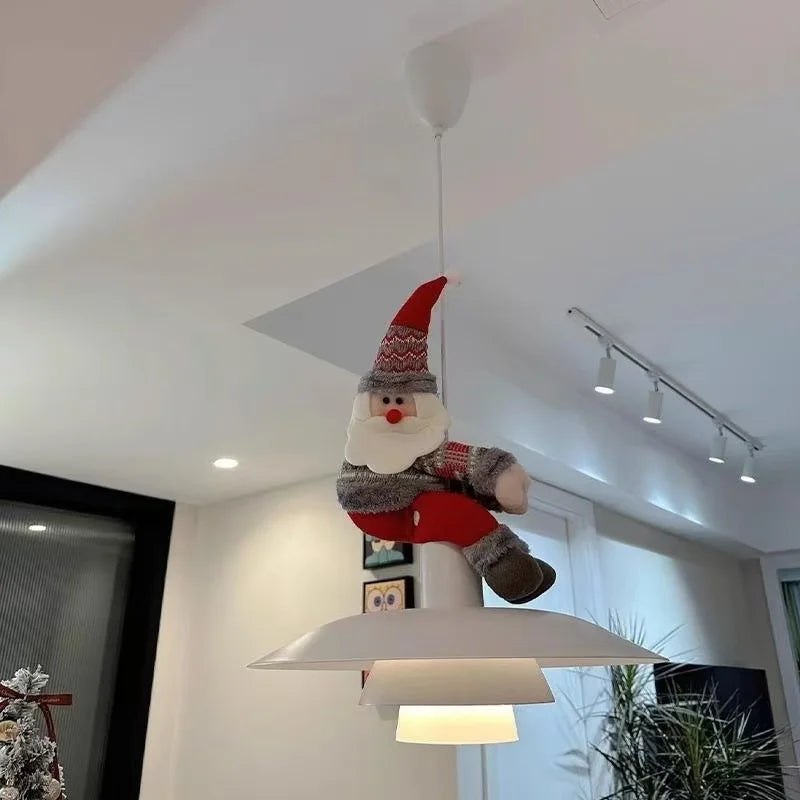 Christmas Chandelier Hugger Santa character perched on a white pendant light in a modern room