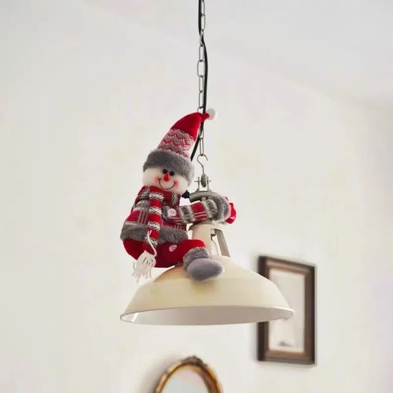 Christmas Chandelier Hugger snowman character seated on a chain-hung pendant lamp