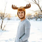 Christmas Moose Hat worn by an adult in a snowy outdoor setting with the side flaps joined under the chin.