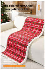 Christmas Sofa Pad Cover in red draped over an armchair with snowflake pattern and plush white trim