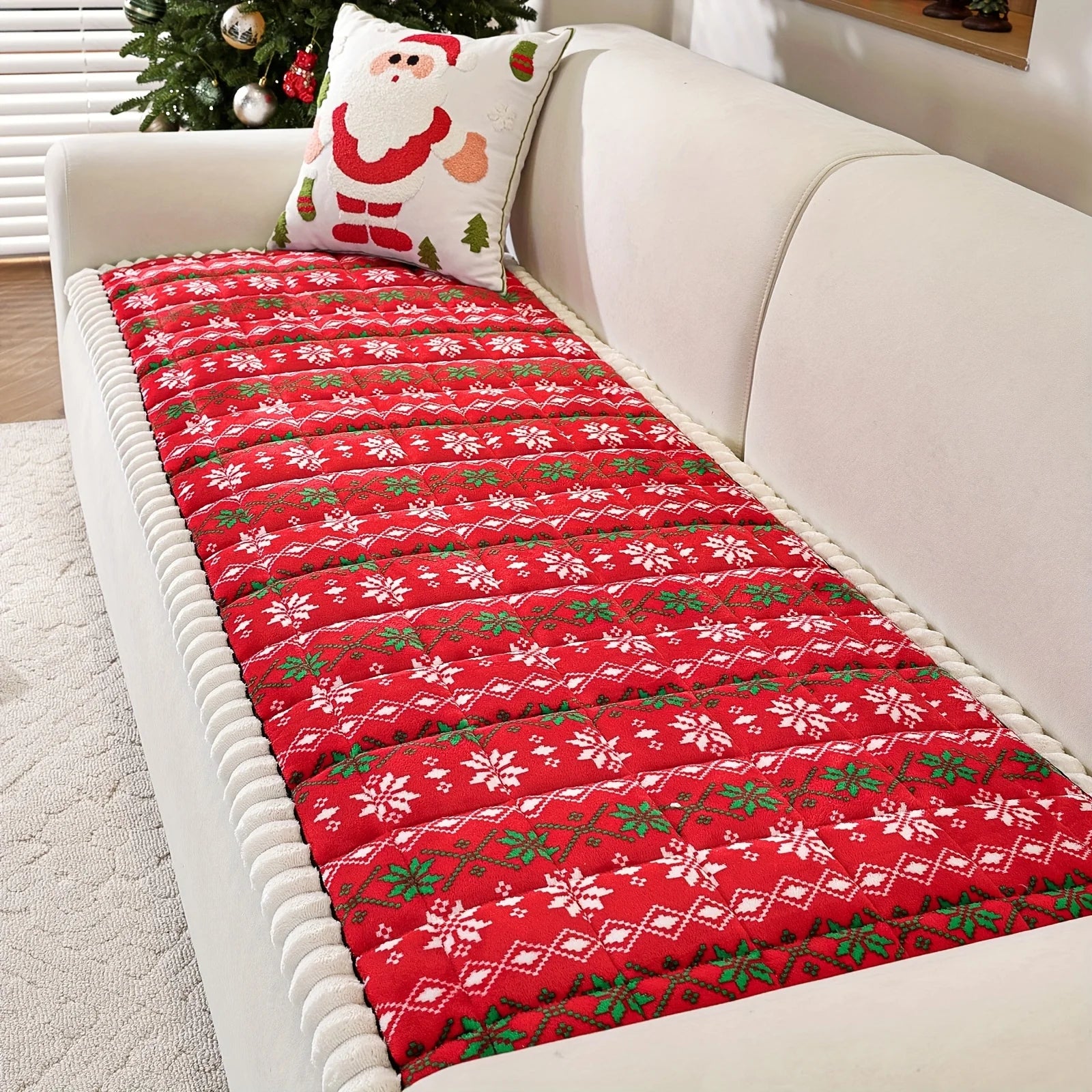 Christmas Sofa Pad Cover in red with white snowflakes and green Nordic details on a cream-colored sofa