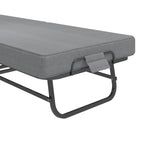Compact Foldaway Guest Bed close-up showing the mattress edge, fabric strap and curved steel leg.