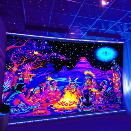 Cosmic Bonfire UV Tapestry with a vivid bonfire and mountain scene displayed under purple room lighting.