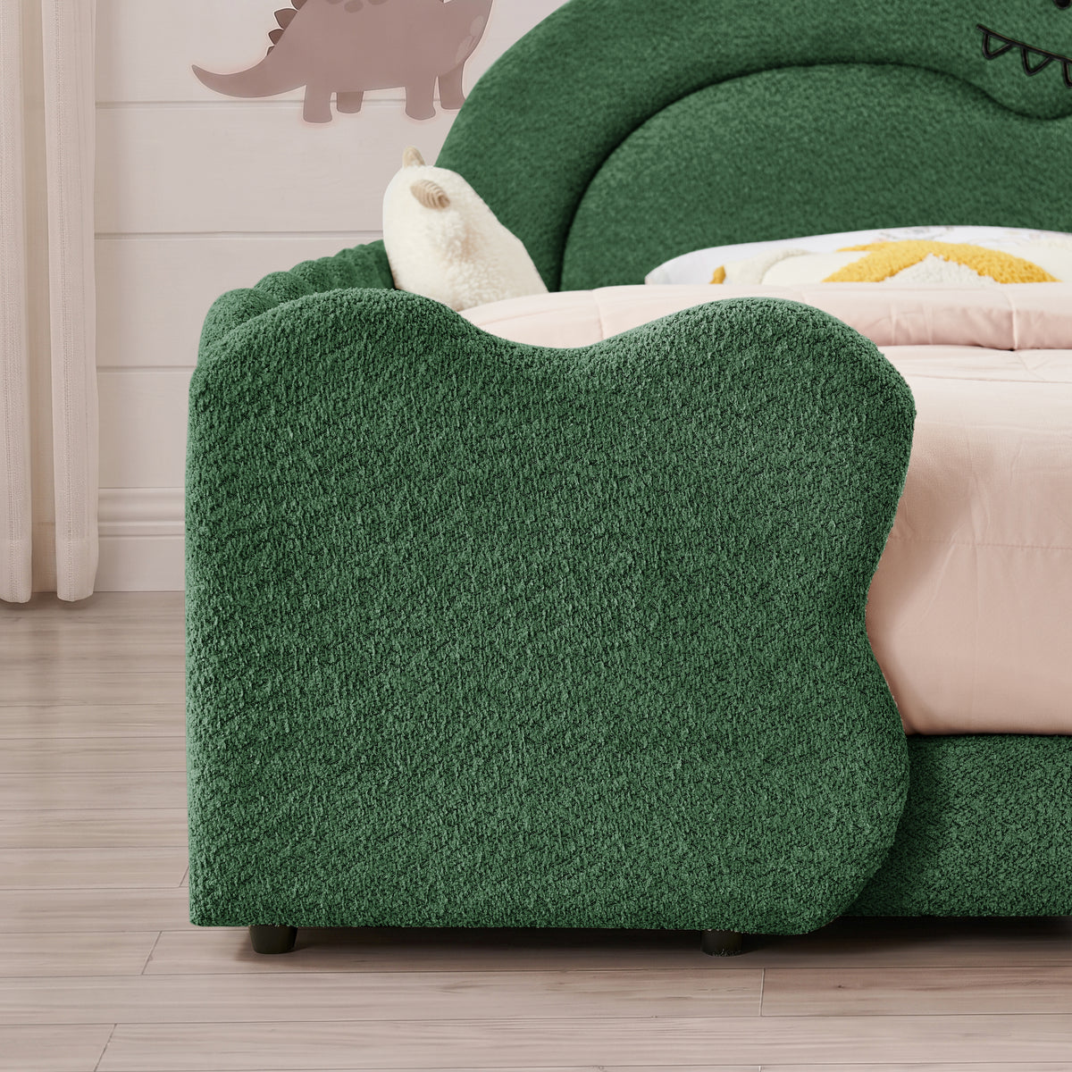 Close-up of rounded green bouclé footboard and textured upholstery
