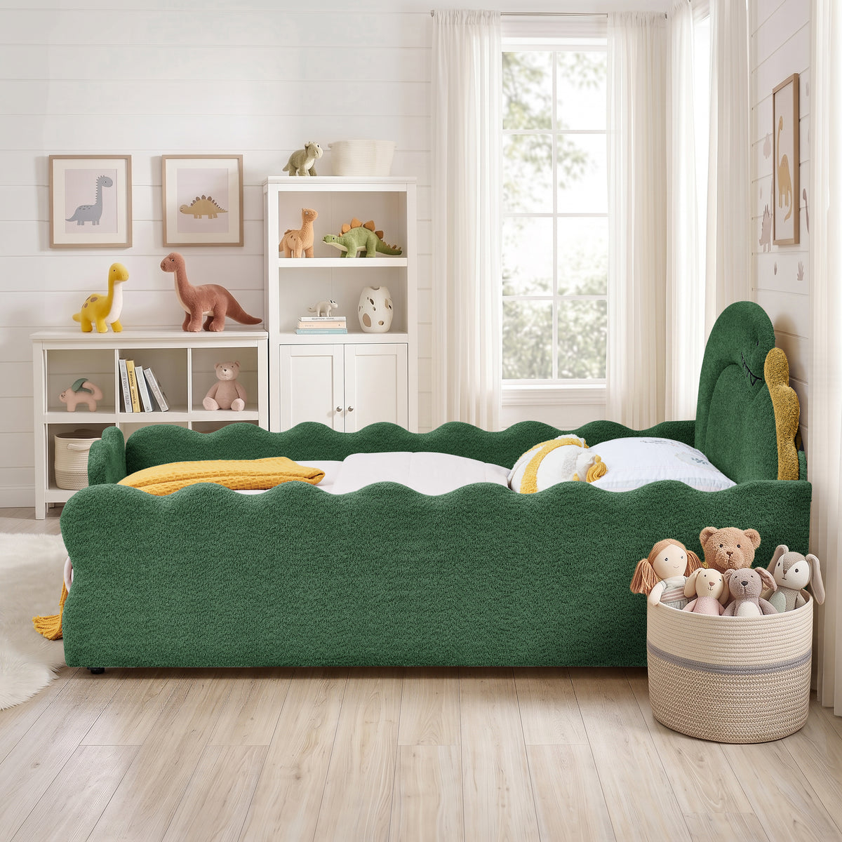Side view of the green dinosaur bed showing the wavy upholstered rails