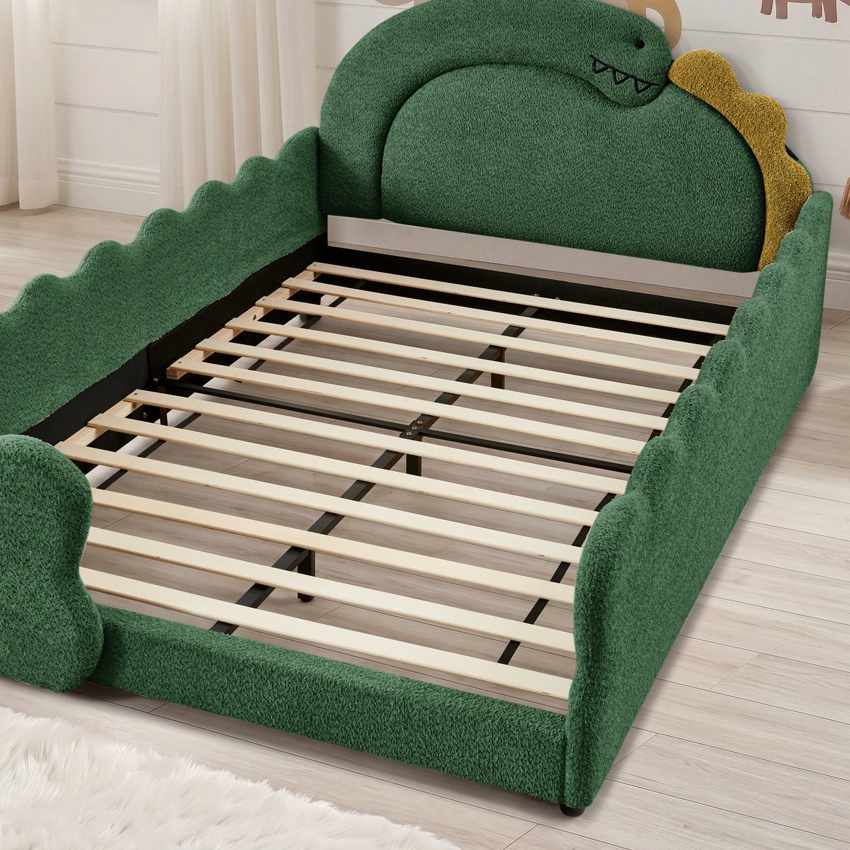 Wood slats and reinforced metal center support inside the green dinosaur bed