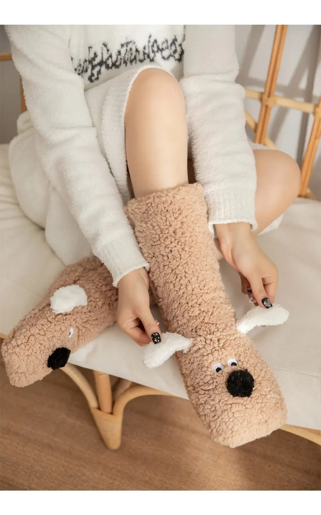 Cozy Dog Ear Socks in khaki in a close-up of a seated wearer lifting the white ears