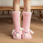 Cozy Dog Ear Socks in pink, worn on a rug with white ears and round white puppy noses