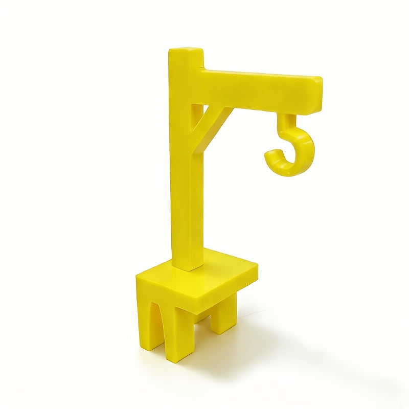 Crane Tea Bag Holder in yellow plastic, showing the crane-shaped arm, open hook and cup-rim clip.