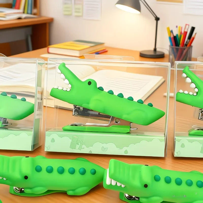 Crocodile Mini Staplers shown in clear display boxes with additional green staplers in front