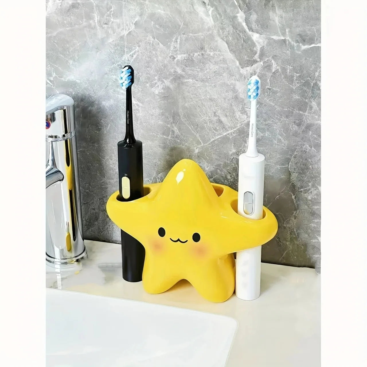 Cute Star Toothbrush Holder organizing black and white electric toothbrushes in its side openings