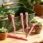 Cute Worm Plant Ornaments: five pink worms arranged beside a green garden caddy and small potted succulents.