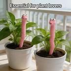 Cute Worm Plant Ornaments: two pink decorative worms in white pots with leafy plants beside a balcony railing.