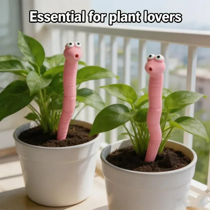 Cute Worm Plant Ornaments: two pink decorative worms in white pots with leafy plants beside a balcony railing.