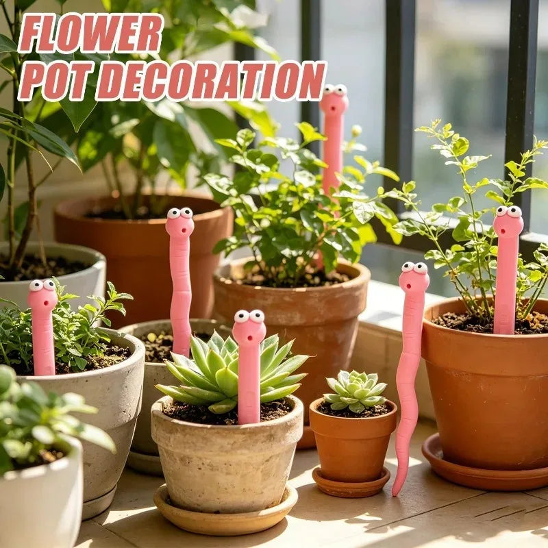 Cute Worm Plant Ornaments decorating assorted terracotta and white plant pots beside a sunny window.