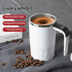 Digital Self-Stirring Mug white mug stirring a drink on gray fabric, with the digital handle display visible.