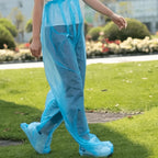 Blue Disposable Rain Pants worn while walking outdoors with integrated foot coverage