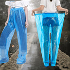 Blue Disposable Rain Pants shown on a wet road with the waistband stretched to demonstrate fit