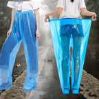 Disposable Rain Pants in blue shown worn on a wet road with the elastic waistband stretched