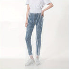 Transparent Disposable Rain Pants shown full length over dark pants and white sneakers