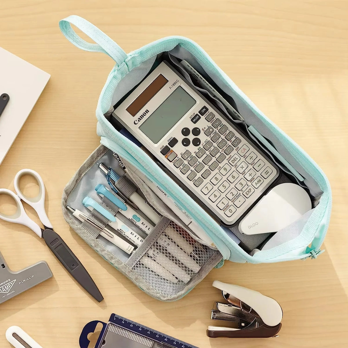 Double Compartment Pencil Case in blue on a desk with a calculator and stationery demonstrating storage.