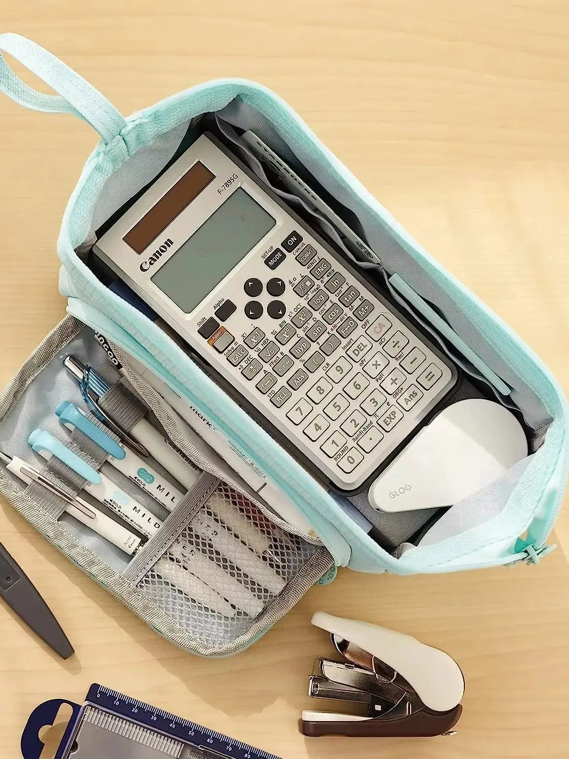 Double Compartment Pencil Case close-up of the blue main compartment with a calculator and small stationery.