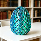 Dragon Egg Fidget Toy in glossy blue and green displayed upright on a desk near bookshelves