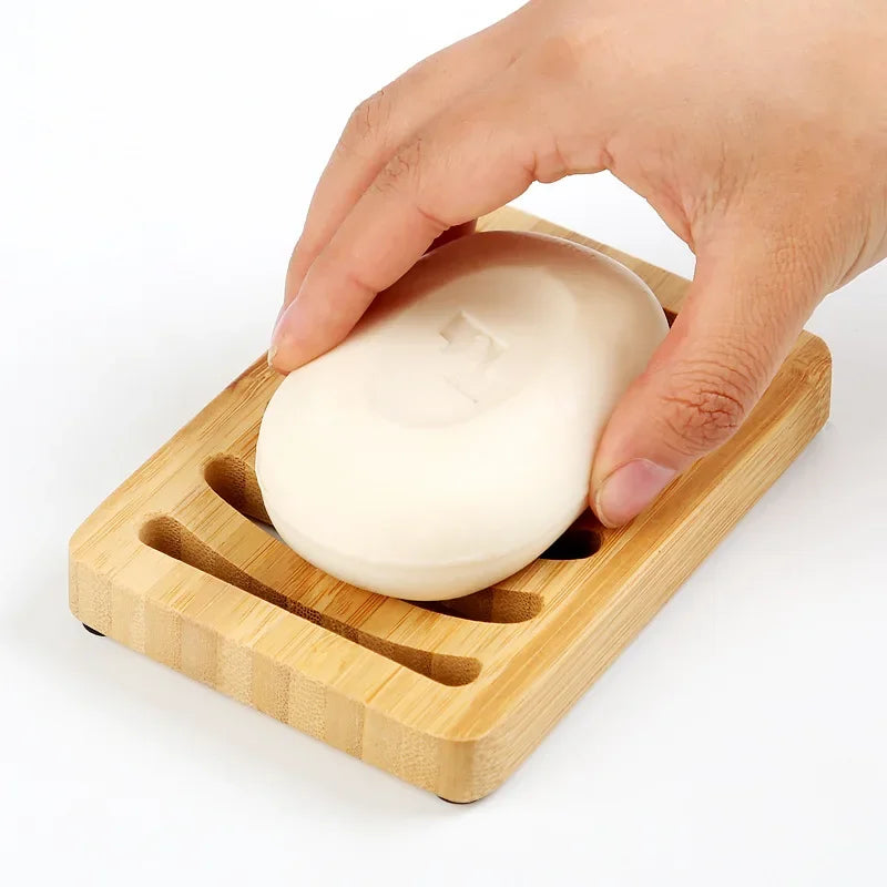 Draining Bamboo Soap Dish close-up as a hand places bar soap on the slotted tray