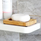 Draining Bamboo Soap Dish holding white bar soap on a bathroom shower shelf